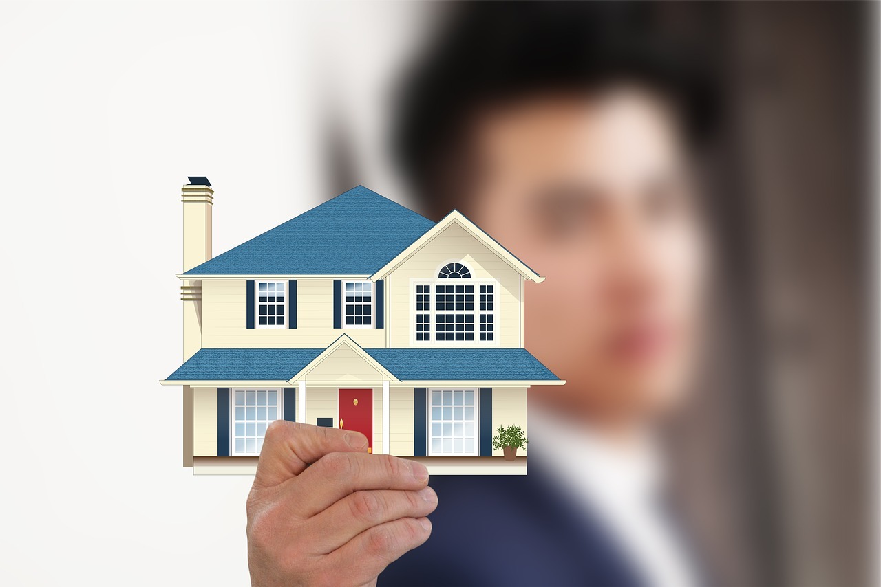 a man holding a miniature picture of a house, denoting a first property investment