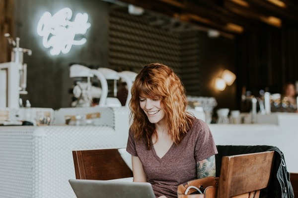 How to Get Votes for Social Media Contest Online? woman sitting on brown wooden chair while using silver laptop computer in room