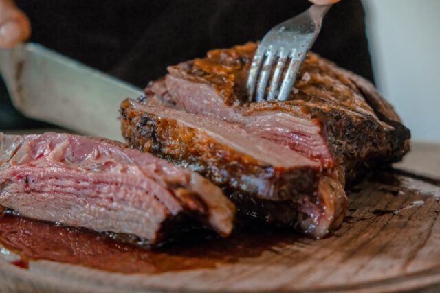 How to Cook Sous Vide person slicing a meat on brown wooden board