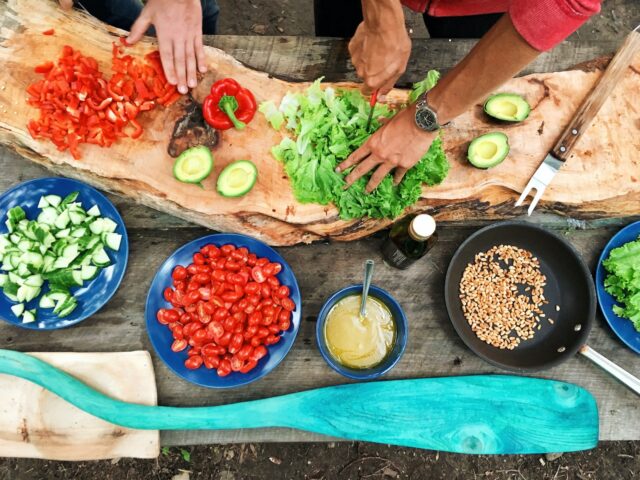 The Ultimate Summer Entertaining Guide For Food And Wine Lovers person slicing green vegetable in front of round ceramic plates with assorted sliced vegetables during daytime