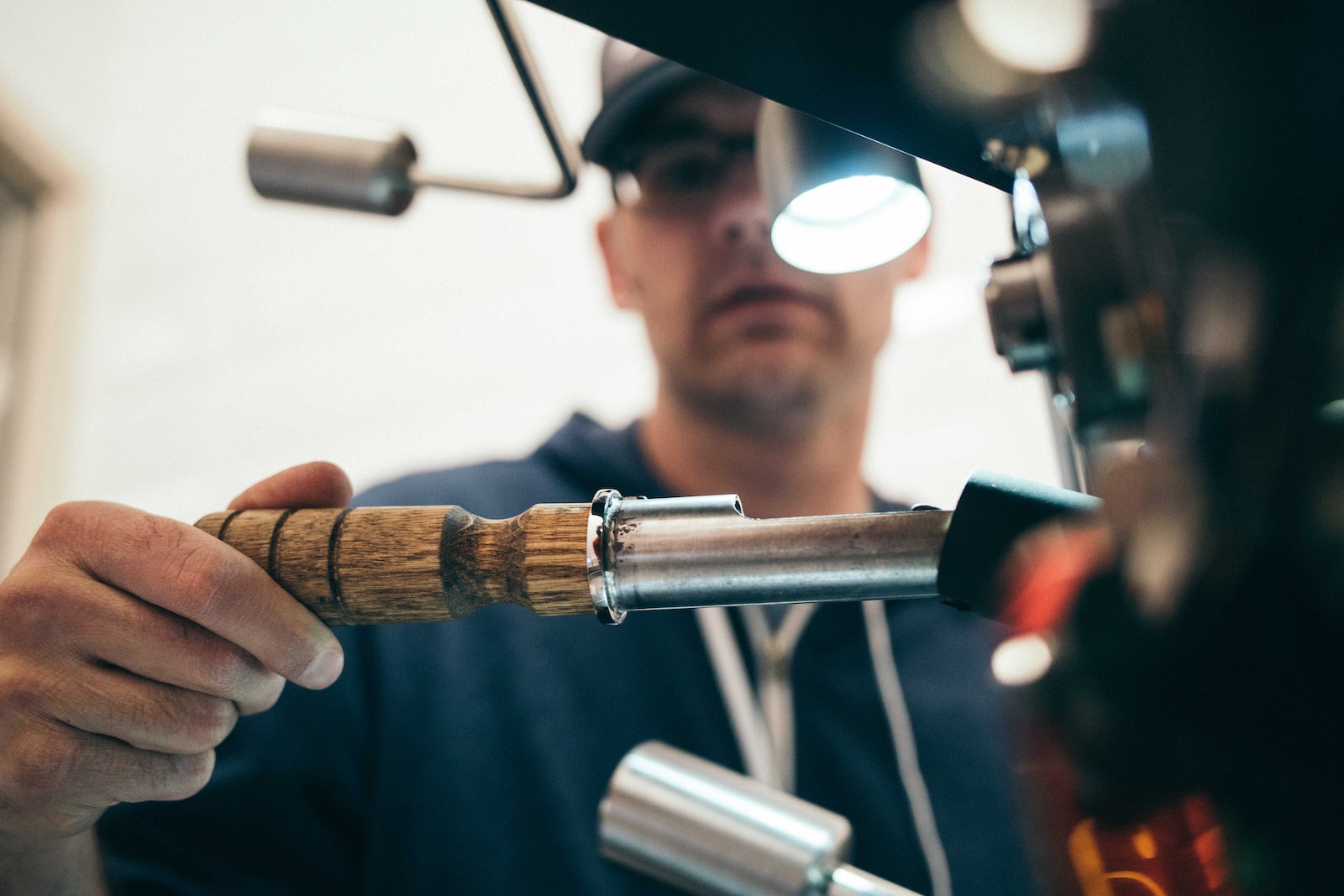 How to spot a plumbing problem in your kitchen man wearing black pullover hoodie holding tool