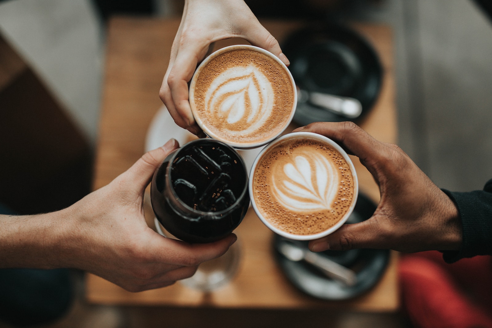 Exploring the Art of Coffee Making with Advanced Machines three person holding beverage cups